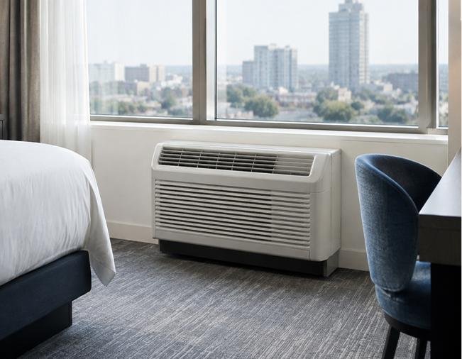 Hotel guestroom with PTAC unit installed beneath the window